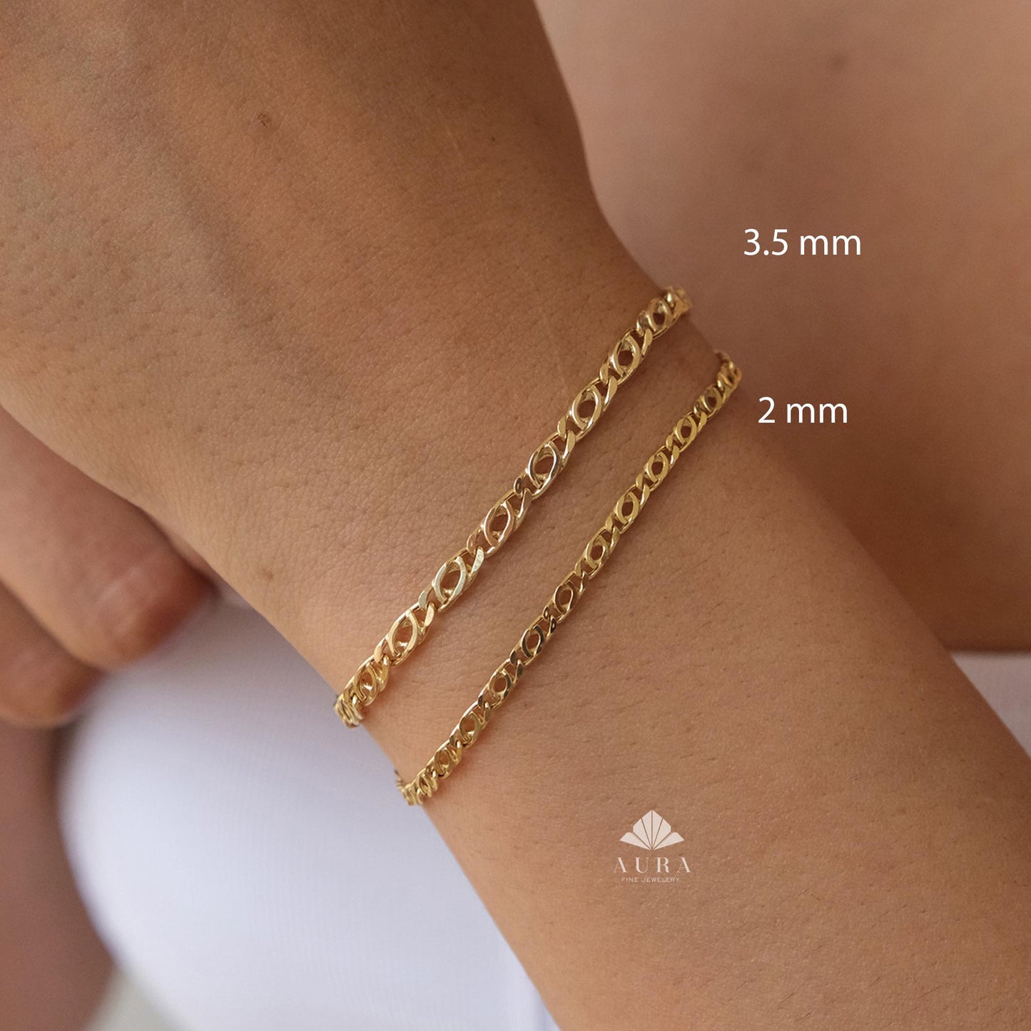 May include: Two gold-colored chain bracelets, 3.5 mm and 2 mm thick, are displayed on a wrist. The bracelets have an oval link design. The image includes the text "3.5 mm" and "2 mm". The logo "AURA" is visible at the bottom.