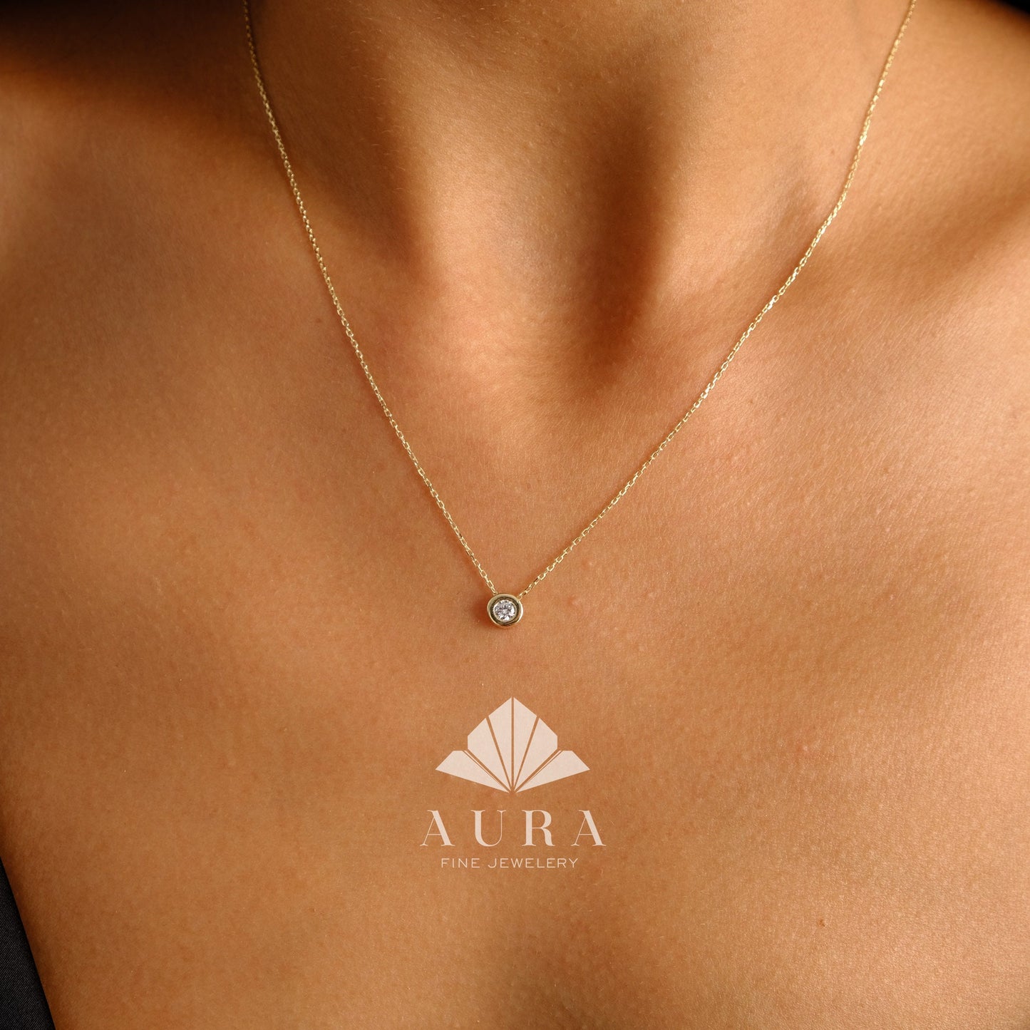 May include: A delicate gold chain necklace with a small, round, bezel-set diamond pendant.